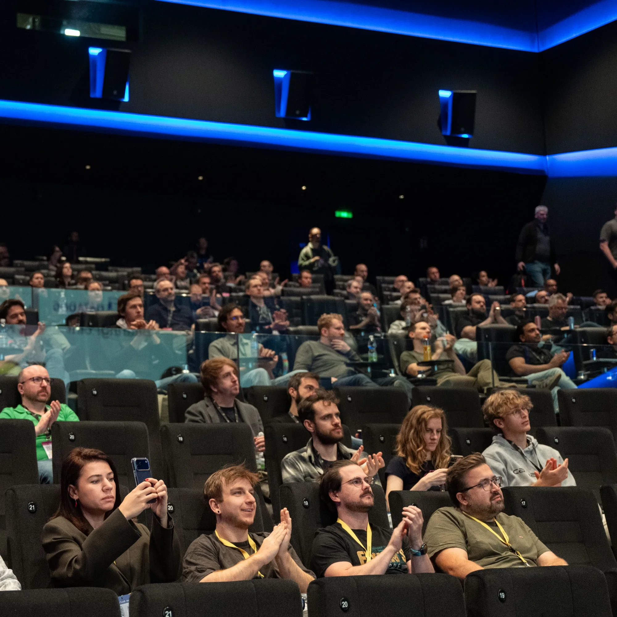 Attendees applauding in the cinema hall during a talk