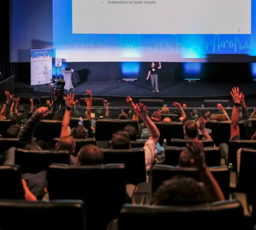The audience of a talk answering the speaker's question by a show of hands