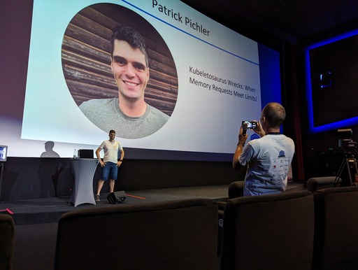 A speaker on stage at being photographed from an organizer